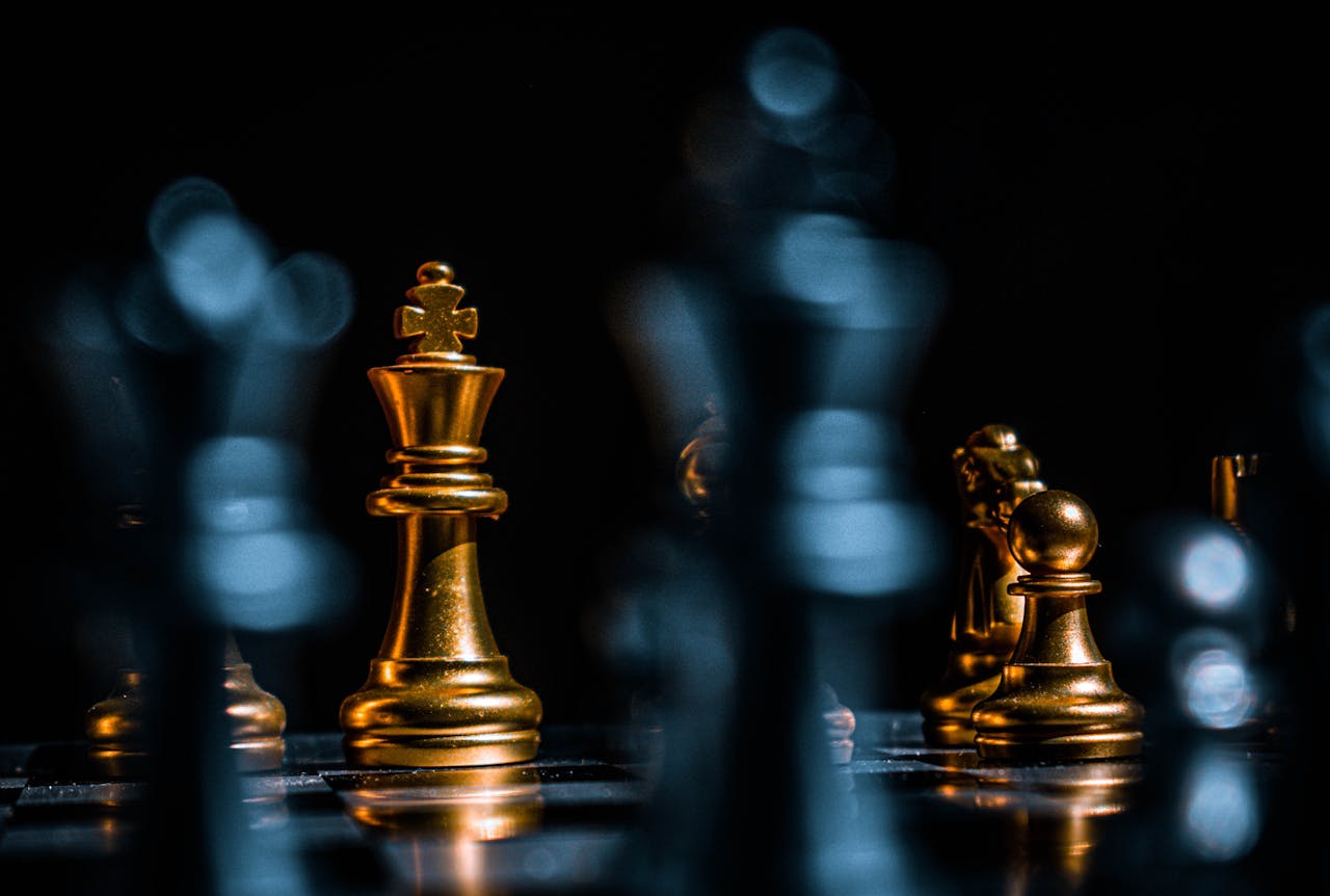 Captivating close-up of gold chess pieces on a board with a dramatic black background.