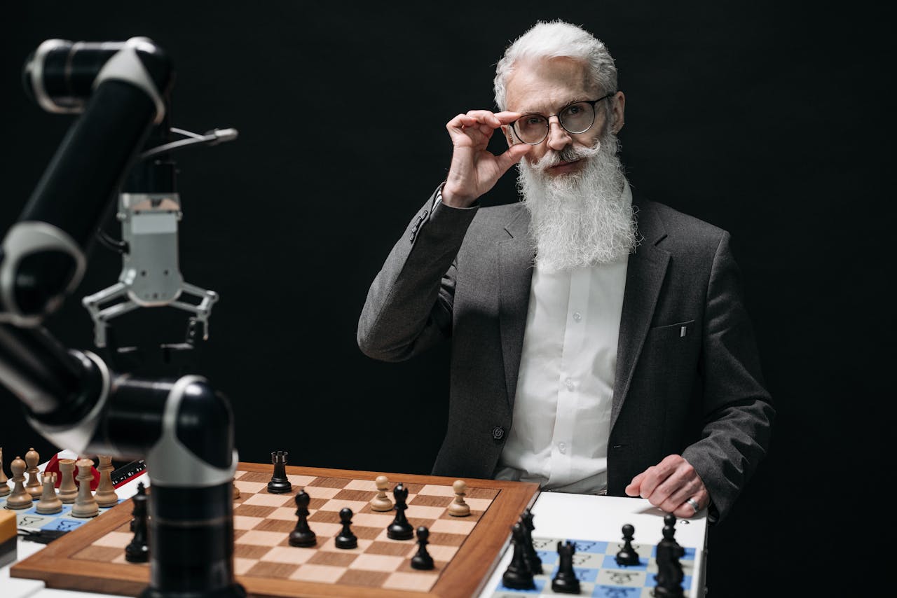 Senior man strategizing in a chess game against a robot, showcasing AI in leisure activities.