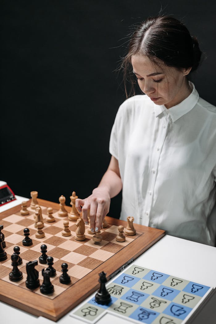 Woman intently playing chess, illustrating deep focus and strategy in a game setting.